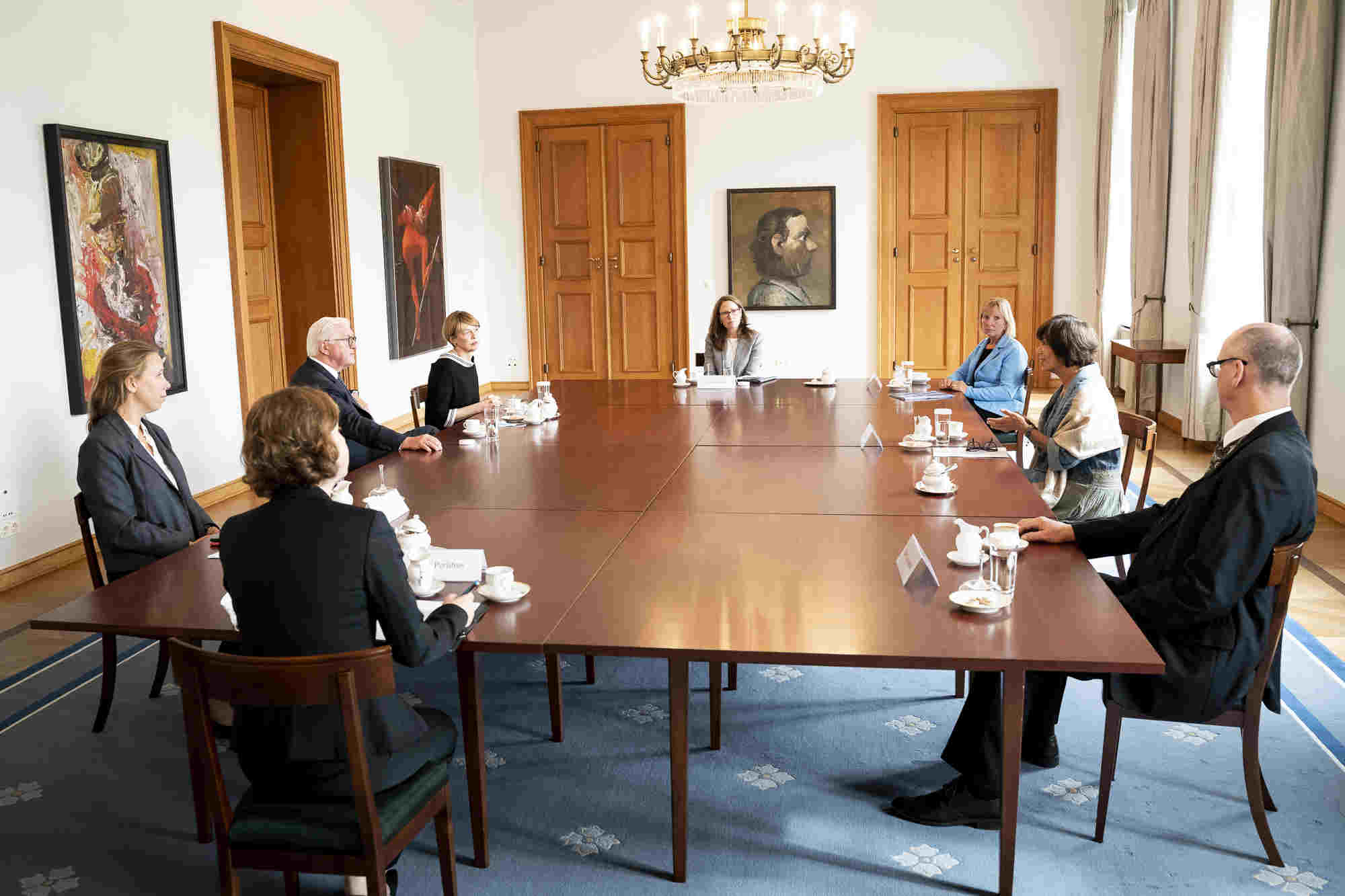 Gäste beim Empfang des Bundespräsidenten sitzen um einen großen Tisch 