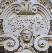 Kopf der Justitia in Stein über dem Eingangsportal des Gerichtes in Berlin Moabit